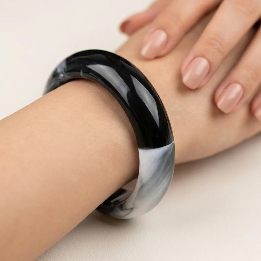 دستبند زنانه بنگل رزینی طرح ابر و باد مدل نُکتیرا–مشکی