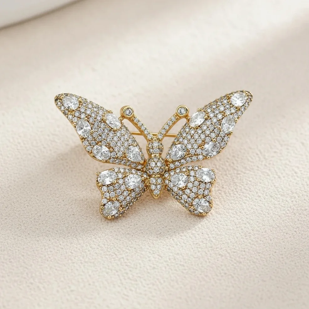 گل سینه زنانه ژوپینگ مدل اوریل فلای طرح پروانه نگین‌دار با جلوه طلایی