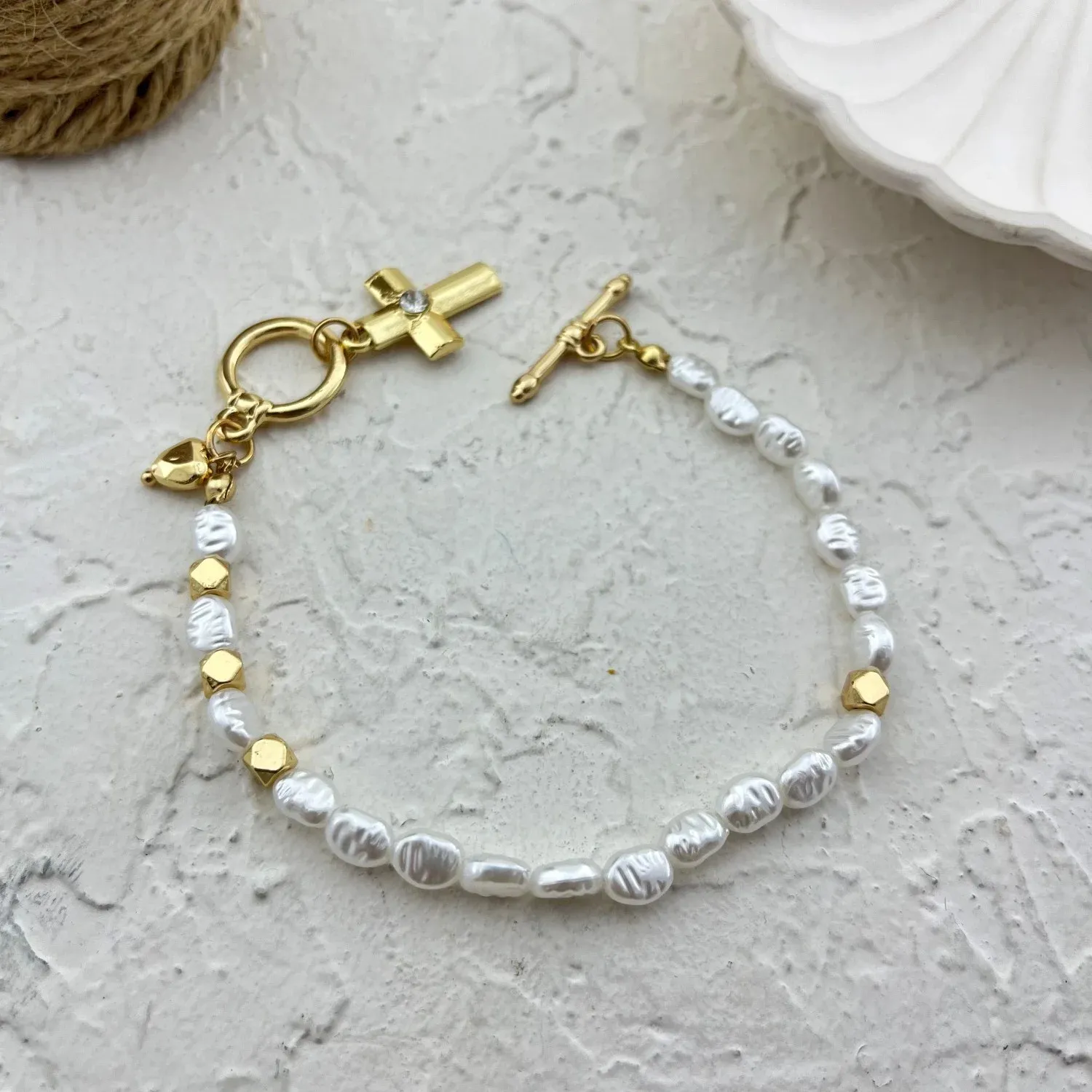 دستبند زنانه مرواریدی با آویز صلیب ظریف و طراحی مدرن